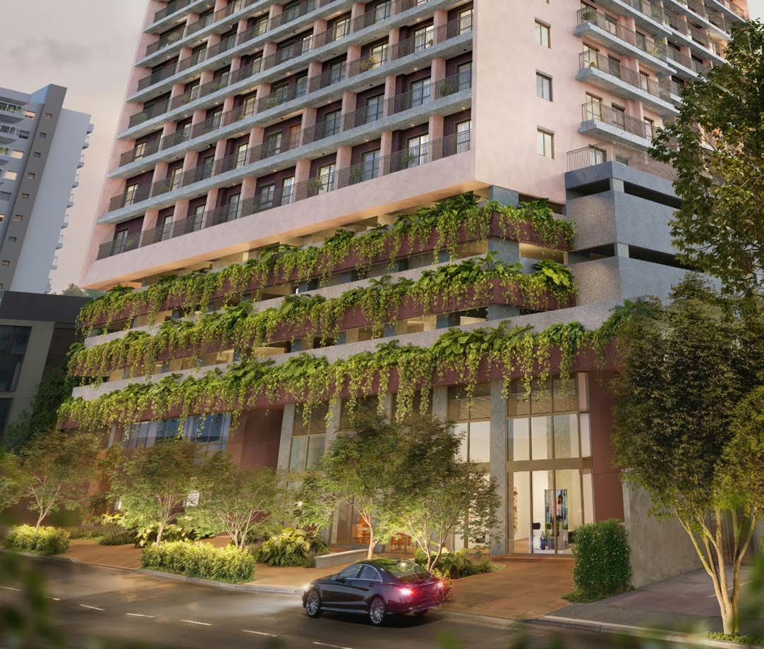 Fachada do Poema Liberdade ao entardecer, com jardins pendentes nos primeiros pavimentos e lojas no térreo